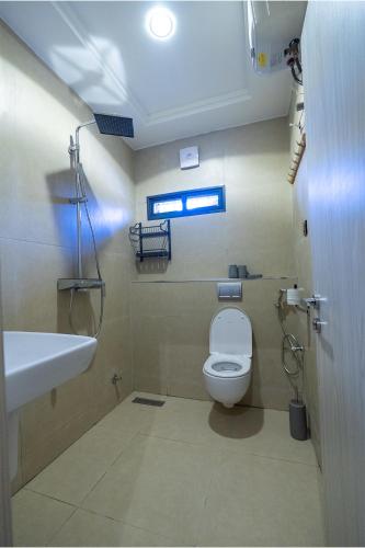 a bathroom with a toilet and a sink at Sanctum Suites in Abuja