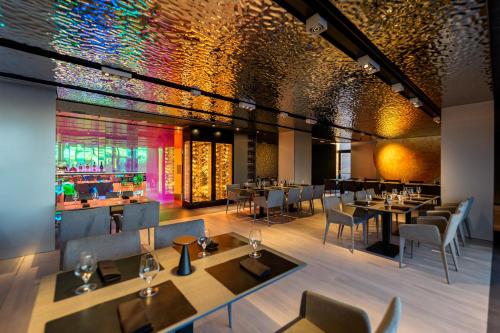 a restaurant with tables and chairs and a bar at Hotel Privo in Târgu-Mureş