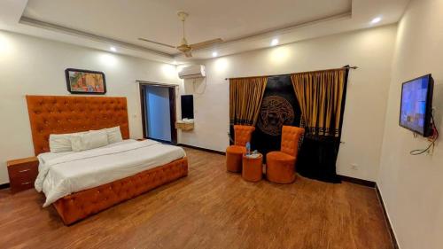 a bedroom with a large bed and wooden floors at Al Shahzan Hotel in Lahore