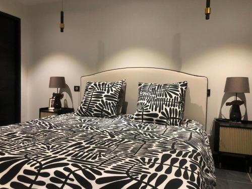 a bedroom with a bed with black and white pillows at Lilas in Huelgoat
