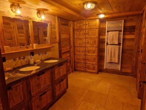 a bathroom with two sinks in a wooden cabin at Les Chryolles -Les Petits loups in Valmeinier