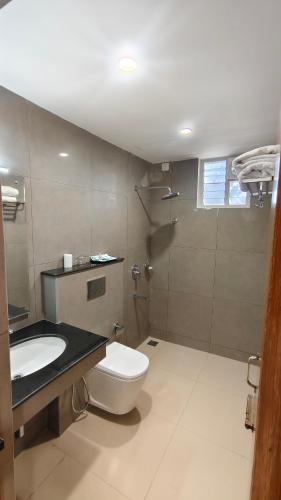 a bathroom with a toilet and a sink and a shower at Darling Grand SME in Vellore