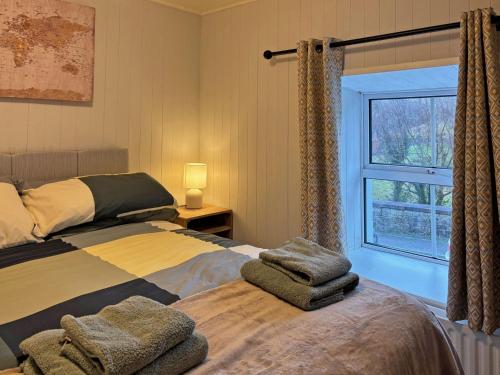 a bedroom with a bed and a window at Cottage 496 - Leenane in Leenaun