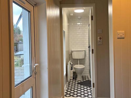 a small bathroom with a toilet and a hallway at Cottage 496 - Leenane in Leenaun