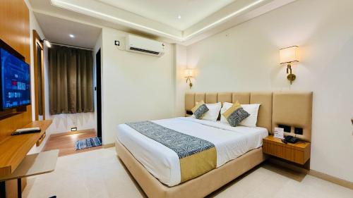 a bedroom with a large bed and a television at Hotel Roop Cliff, Bhopal in Bhopal
