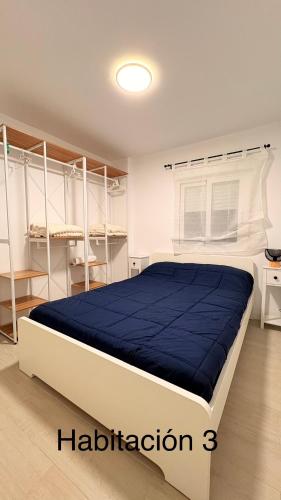 a bedroom with a large bed with blue sheets at Las Colinas in Illana