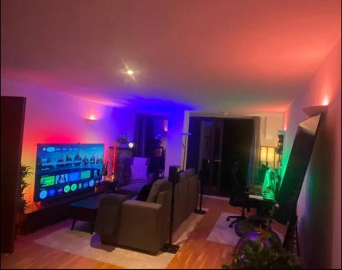 a living room with purple and green lights at Advent House Ancoats Hosted Apartment in Manchester