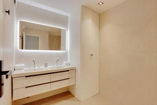 a bathroom with a sink and a mirror at Charming Apt with AC & balcony in Suresnes