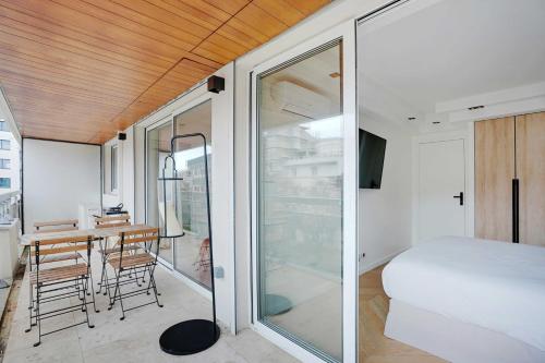 a bedroom with a bed and a table in a room at Charming Apt with AC & balcony in Suresnes