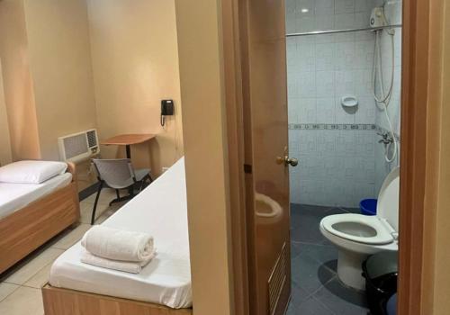 a small bathroom with a toilet and a shower at JL Suites by Hiverooms in Cebu City