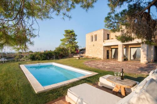 an external view of a villa with a swimming pool at Majestique Villa Aegina in Egina