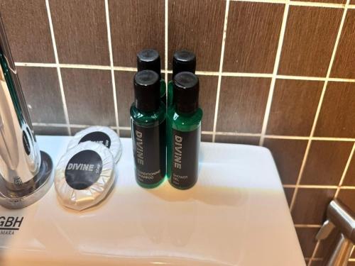 two bottles of liquids sitting on top of a toilet at My Hotel @ Sentral in Kuala Lumpur