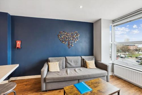 a living room with a couch and a tree on the wall at 'Bright Gem by the Sea' Premium Central 2 bedroom flat in Brighton & Hove