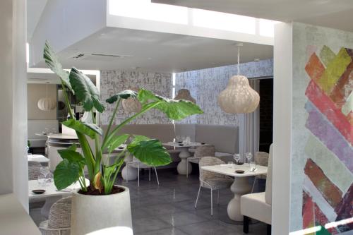 ein Esszimmer mit Tischen und einer Topfpflanze in der Unterkunft Hostellerie Saint Germain in Saint-Germain-lès-Arlay