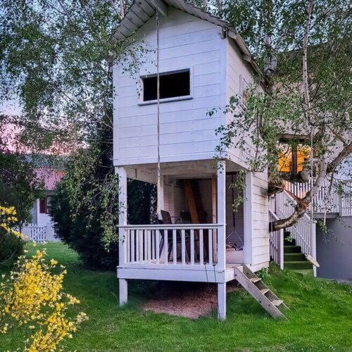 a play house with a porch in the yard at Garden Lodge Minou in Hirschwang
