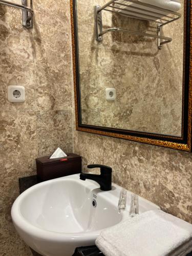 a bathroom with a sink and a mirror at Zam Hotel By Pavotel in Kedungbadak