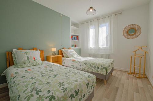 a bedroom with two beds and a window at Le marguette in Poivres