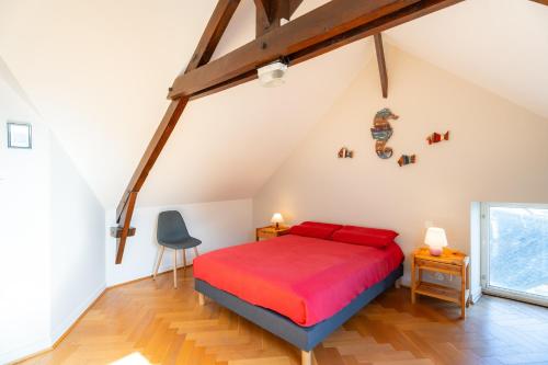 a bedroom with a red bed in a attic at Les Géraniums - Maison avec terrasse - Baden in Baden