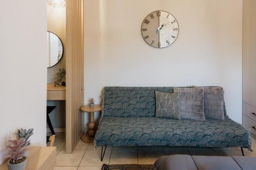 a living room with a couch and a clock on the wall at Zoe's Luxury Living in Volos
