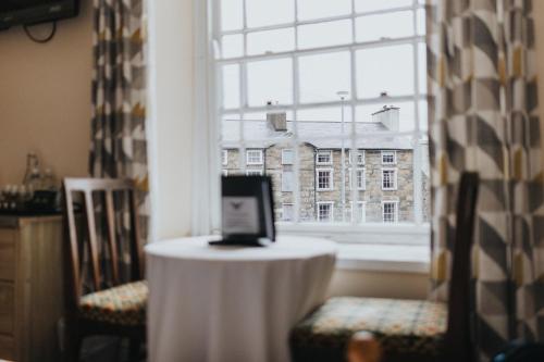 a table with a laptop on it in front of a window at Y Pengwern in Ffestiniog