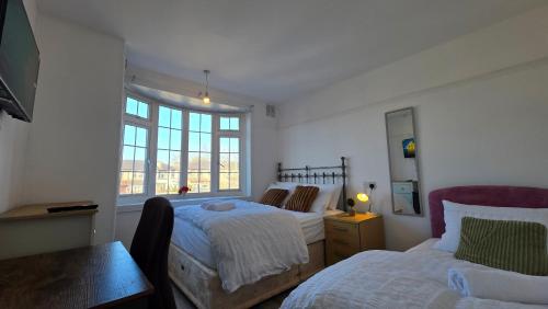 a bedroom with two beds and a window at Nice Living Serviced Accommodations 15 in Allesley