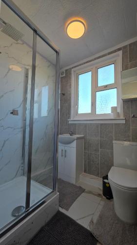 a bathroom with a glass shower and a toilet at Nice Living Serviced Accommodations 15 in Allesley