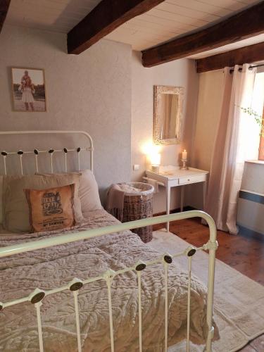 a bedroom with a bed and a table and a window at L'Amour Toujours in Saint-Julien-le-Petit