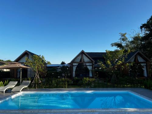 a swimming pool in front of a house at Tuyo Homestay in Ban Pang Kiang