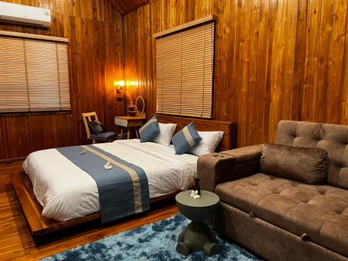 a bedroom with a bed and a couch at Tuyo Homestay in Ban Pang Kiang