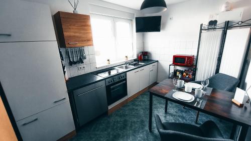 a kitchen with a table and a sink and a refrigerator at Ferienwohnung Nauen in Nauen