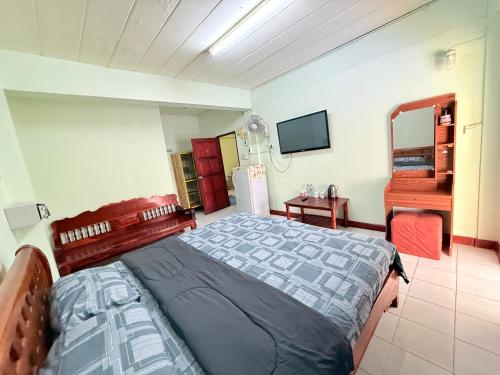 a bedroom with a bed and a television in it at Bambus Motel in Jomtien Beach