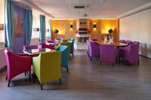a dining room with colorful chairs and tables at Waldhotel Bärenstein in Horn-Bad Meinberg