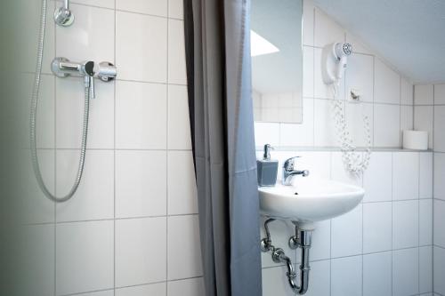 a bathroom with a sink and a shower at Hotel Eintracht in Fellbach