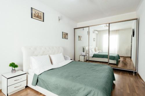 a bedroom with a large bed and a mirror at Central Park Apartment 4 Guests in Chişinău