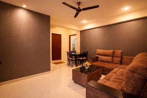 a living room with a couch and a ceiling fan at Aafiya lakeview Apartments in Coimbatore