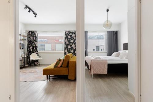 two views of a bedroom with a bed and a chair at Funky City Apartment By Lapland Host in Rovaniemi
