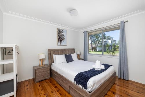 a bedroom with a bed and a window at Barefoot Bungalow in Nelson Bay