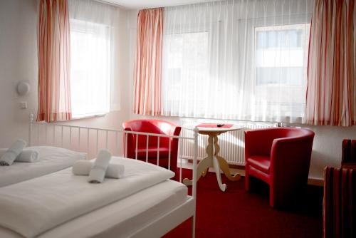 a room with two beds and a table and chairs at Hotel Eintracht in Fellbach