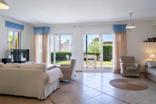 a living room with a couch and a tv at Villa Avra in Panormos Rethymno