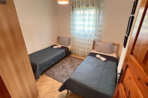 two beds in a small room with a window at Finikas Garden Home in Karianí