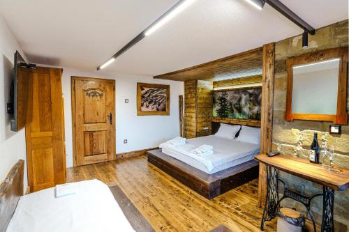 a bedroom with a bed and a wooden wall at Разбойна in Zheravna