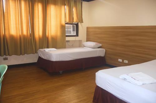 a hotel room with two beds and a window at YMCA of Manila Hostel in Sampong