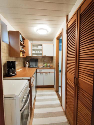 a kitchen with white appliances and wooden cabinets at Ferienwohnung Iris in Radolfzell am Bodensee