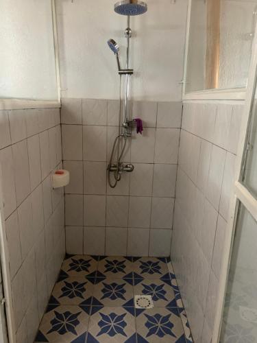 a bathroom with a shower with a tiled floor at Palm Garden Resort in Gisenyi