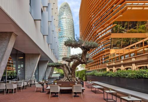 a restaurant with a tree in the middle of buildings at Hotel SB Glow 4 Sup in Barcelona