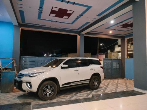 a white suv parked in a garage at Hotel Keshav in Rīngas