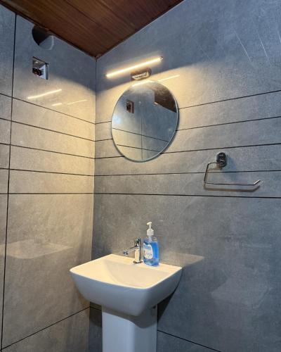 a bathroom with a sink and a mirror at Pebbles in Thirunelli