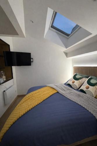 a bedroom with a large bed with a skylight at Family in Calais