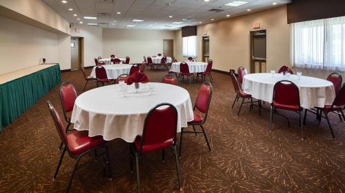 a conference room with tables and chairs with red chairs at Best Western Philadelphia South - West Deptford Inn in Thorofare