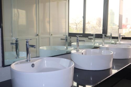 a bathroom with four sinks and faucets on a counter at YMCA of Manila Hostel in Sampong